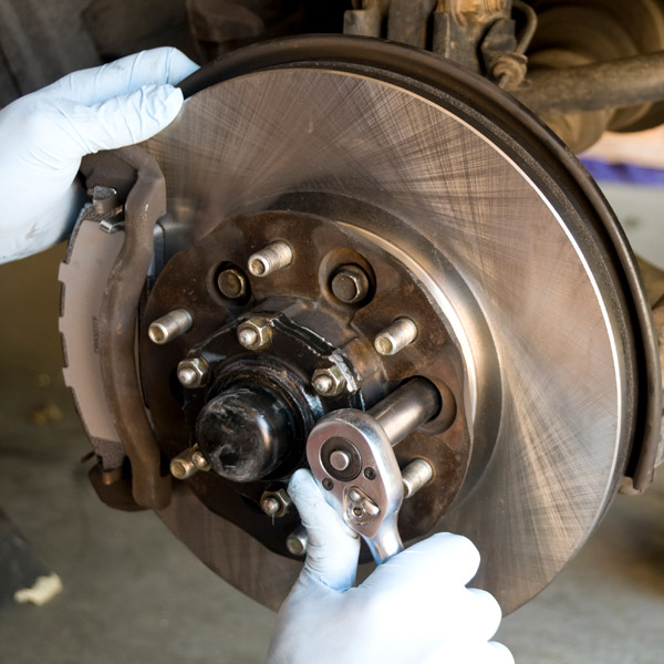 close up of mechanic working on brakes