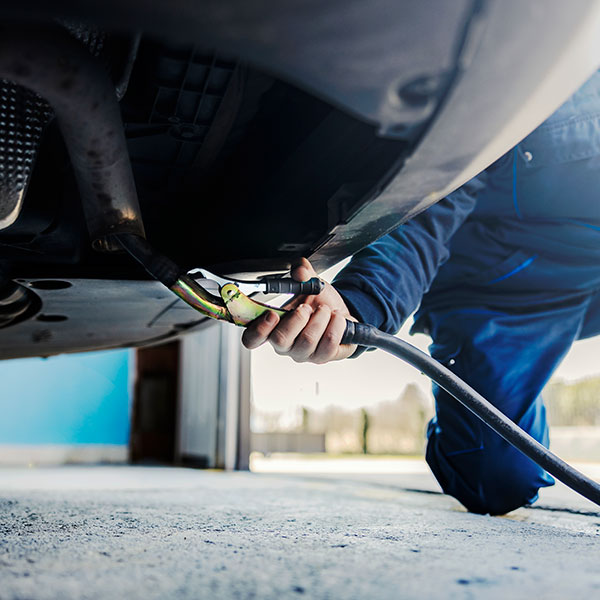 a worker repairing car silencer