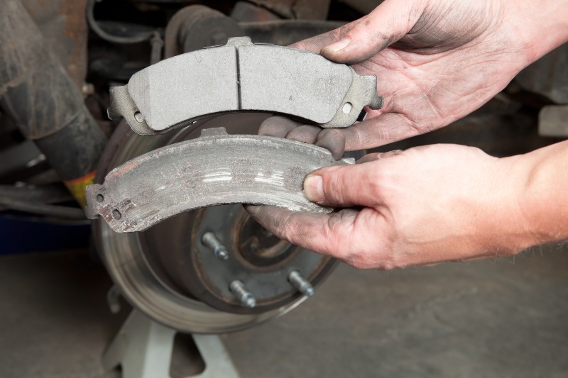 Mechanic replacing old brake pad with a new one in Millersville, MD